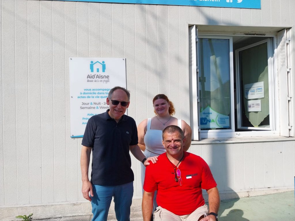 David Havram, président de Cocci N'Roule pose devant les bureaux de Aid'Aisne avec sa fille et M. Dominique Villa