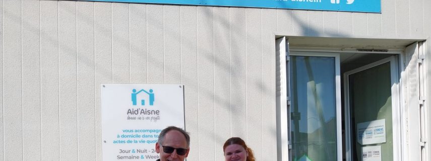 David Havram, président de Cocci N'Roule pose devant les bureaux de Aid'Aisne avec sa fille et M. Dominique Villa
